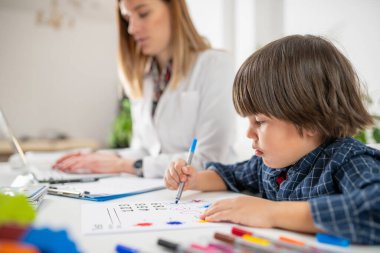 Küçücük bir çocuk olarak küçük bir zeka bir psikologun rehberliğiyle bir psikoloji testinde ustaca yol alıyor.