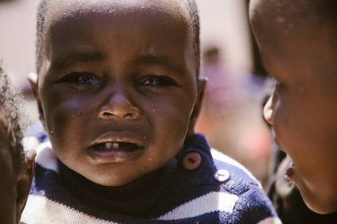 Kitale, Kenya - 02.03.2017: Evsiz çocuklara yardım etmek için hayır kurumundan bir misyoner ekibi geldi. Yiyecek, giyecek ve su paylaşıyorlar. Afrika 'da açlık ve işsizlik. Yiyecek yetersizliğinden ağlayan zavallı bir çocuğun portresi..