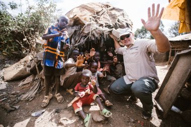 Kitale, Kenya - 02.03.2017: Evsiz çocuklara yardım etmek için hayır kurumundan bir misyoner ekibi geldi. Yiyecek, giyecek ve su paylaşıyorlar. Afrika 'da açlık ve işsizlik. Fakir ailelerden yırtık elbiseli çocuklar..