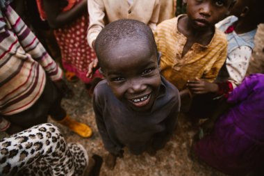 Kitale, Kenya - 02.03.2017: Evsiz çocuklara yardım etmek için hayır kurumundan bir misyoner ekibi geldi. Yiyecek, giyecek ve su paylaşıyorlar. Afrika 'da açlık ve işsizlik. Afrikalı Amerikalı bir çocuğun portresi.