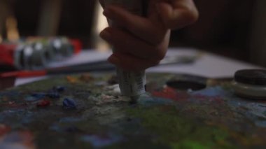 Kız tuval üzerine bir resim çiziyor. Boya Fırçası kullanan sanatçı. Sanatçı palette boya karıştırır.