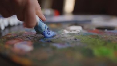Kız tuval üzerine bir resim çiziyor. Boya Fırçası kullanan sanatçı. Sanatçı palette boya karıştırır.