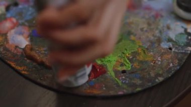 Kız tuval üzerine bir resim çiziyor. Boya Fırçası kullanan sanatçı. Sanatçı palette boya karıştırır.