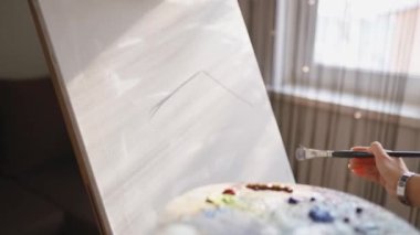 Kız tuval üzerine bir resim çiziyor. Boya Fırçası kullanan sanatçı. Sanatçı palette boya karıştırır.