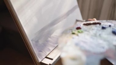 Kız tuval üzerine bir resim çiziyor. Boya Fırçası kullanan sanatçı. Sanatçı palette boya karıştırır.