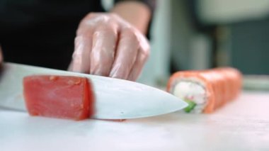 Şef suşi, rulo hazırlar. Philadelphia 'da ton balığı, avokado, yengeç ve peynirli.