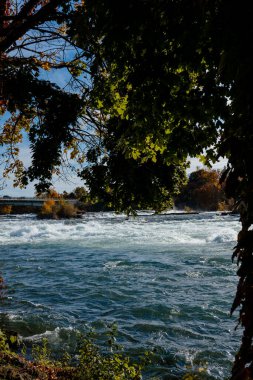 Amerikan ve Kanada 'dan Niagara Şelaleleri. Şelalenin üstünde gökkuşağı. En popüler turistik yer. Göle akan fırtınalı nehir.