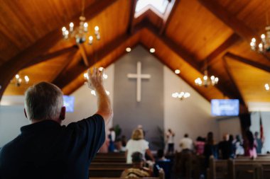 Cleveland, OH, USA - 05.15.2022: A man prays in a Protestant, Baptist, Catholic church. Praise and worship in the church. People glorify God and worship him. clipart