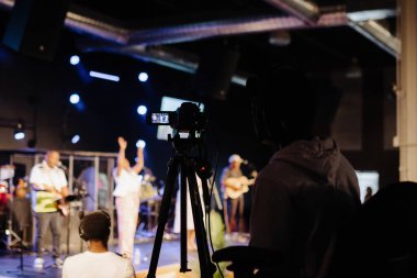 Cleveland, OH, USA - 05.15.2022: Kilisede canlı yayın. Kameranın arkasındaki operatör canlı yayın yapıyor. Telefonundan sosyal ağlarda çevrimiçi video. Video konferansı.