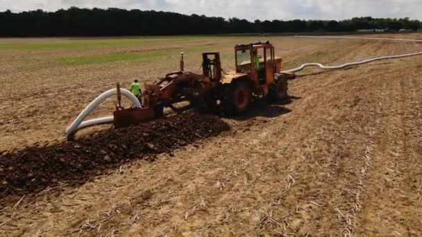 パイプ敷設機械は地面を掘り フィールドにパイプを敷設します 排水システムの構築 — ストック動画