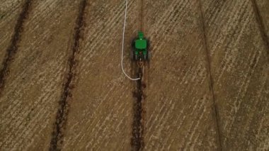 Boru döşeme makinesi zemini kazar ve boruyu tarlaya döker. Bir drenaj sistemi oluşturuluyor.