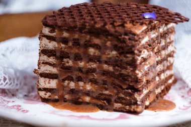 Modern şekerleme hamur işi - bir parça lezzetli katmanlı kahve bal keki (kahve medovik) ve tuzlu karamelli krema