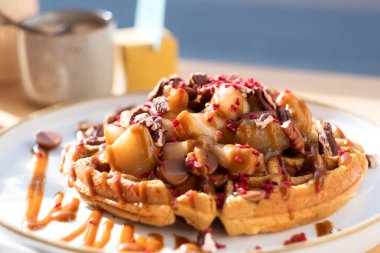 Krem şantili sıcak Belçika waffleları, böğürtlen, çikolata, karamel ve saf akçaağaç şurubu