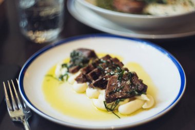 Kurutulmuş patates püresi ve sarımsak soslu sığır dili.