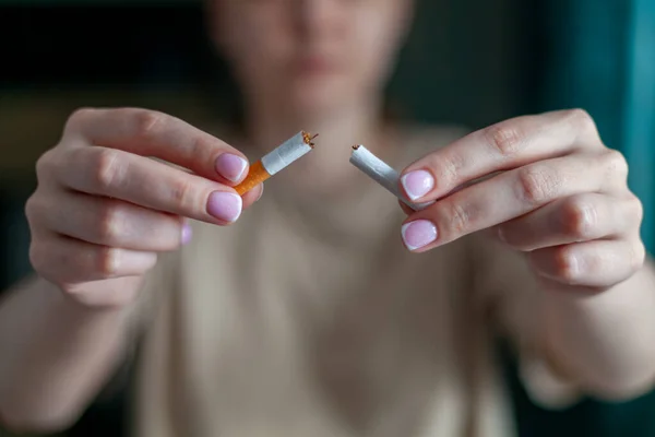 stock image Break a cigarette. A woman holds a broken cigarette in her hands. Happy woman shows a broken cigarette in her palm. Quit bad habit, healthcare concept. Quit smoking