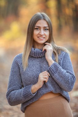 Sonbahar ormanında kalın kazak giyen güzel beyaz bir kadının portresi.