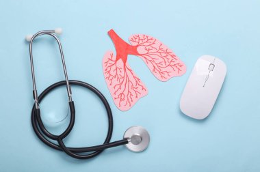Kağıt kesiği anatomik insan akciğerleri, steteskop ve mavi pastel arka planda bilgisayar faresi. Akciğer hastalıklarının teşhisi. Üst görünüm