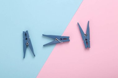 Mavi-pembe renkli arka planda plastik mandallar. Üst görünüm