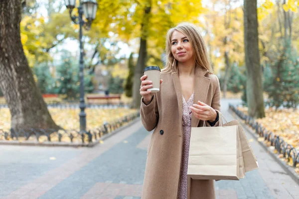 Счастливая Женщина Пальто Проведение Сумки Покупок Чашки Кофе Открытом Воздухе — стоковое фото
