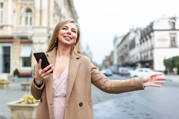 Blondýnka Chytá Auto Drží Smartphone Gestem Ruky Evropském Městě Objednávky — Stock fotografie