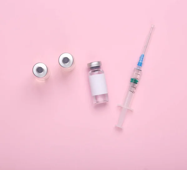 ピンクの背景にブランドと注射器のための空白のラベルを持つワクチンボトル Covid 19ワクチン接種 — ストック写真