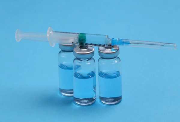 Glazen Flessen Vaccin Met Een Spuit Een Blauwe Achtergrond — Stockfoto