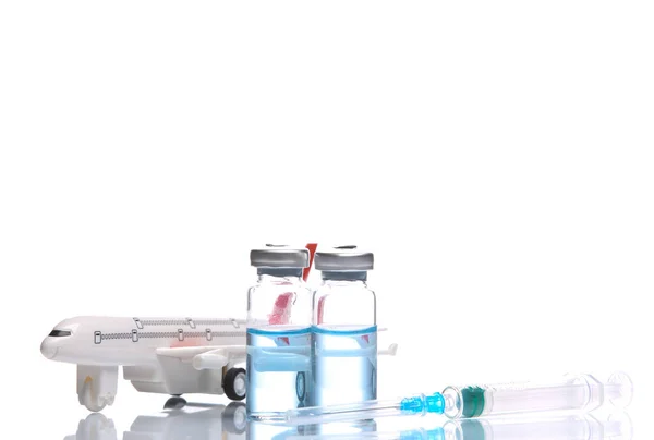 白い背景に反射して隔離されたワクチンボトルと航空機でシリンジ 予防接種だ 旅行のコンセプト — ストック写真