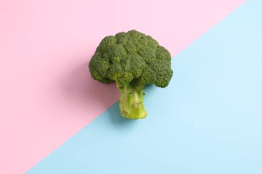 Pembe mavi arka planda brokoli. Sağlıklı gıda konsepti. Üst görünüm