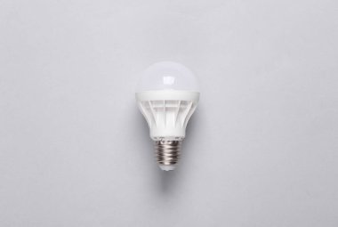 Ekonomi öncülüğündeki ampul gri arka planda. Üst görünüm