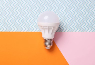 Ekonomi öncülüğündeki ampul renkli arka planda. Üst görünüm
