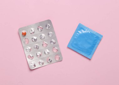 Doğum kontrol hapı. Pembe arka planda doğum kontrol haplarının su toplaması.