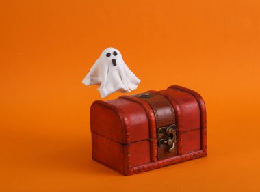 Turuncu arka planda bir korsan sandığını koruyan hayalet. Cadılar Bayramı konsepti
