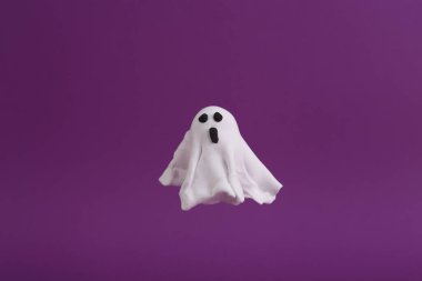 Mor arka planda el yapımı plastik hayalet. Cadılar Bayramı konsepti Şeker mi şaka mı?
