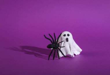 Mor arka planda örümceği olan küçük hayalet. Cadılar Bayramı hayat dolu