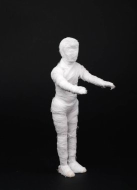 Siyah arka planda bandajlara sarılı oyuncak bebek. En az Cadılar Bayramı konsepti