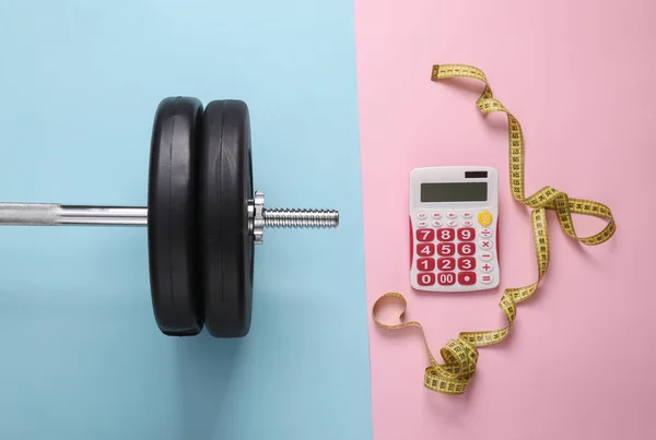 Bodybuilding and fitness, calorie counting, muscle gain and/or weight loss concept. Barbell and calculator with measuring tape on blue-pink pastel background