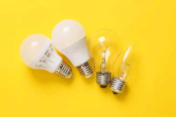Led light bulb and incandescent bulbs on yellow background. Top view