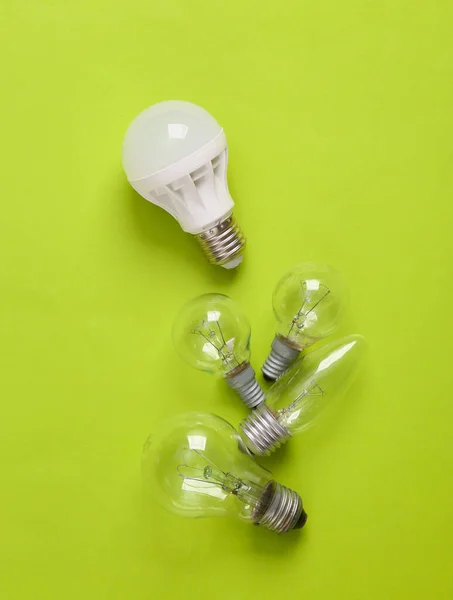Save energy, eco concept. Led light bulb, incandescent light bulbs on a green background.