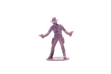 Beyaz arka planda tabancaları olan bir kovboyun plastik figürü.