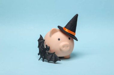 Cadılar Bayramı kumbarası Cadı şapkası ve mavi arka planda yarasa