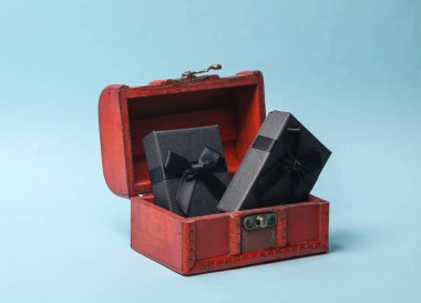 Mavi arka planda bir korsan sandığında siyah hediye kutuları.