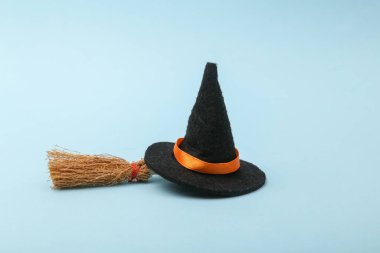 Halloween decor. Witch hat with broom on blue background
