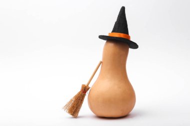 Halloween pumpkin with witch's broom and hat isolated on white background
