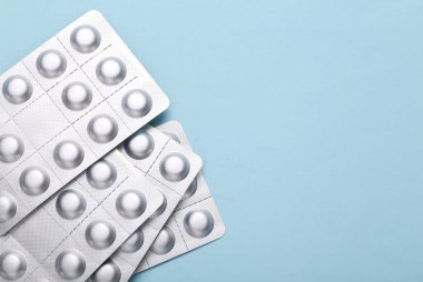 Metal blisters pills on a blue background. Copy space. Top view