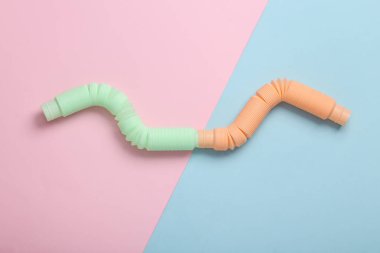 Antistretch pop tubes toy on pink blue pastel background. Top view