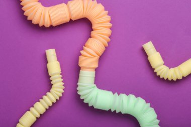 Antistretch pop tubes toy on purple background. Top view