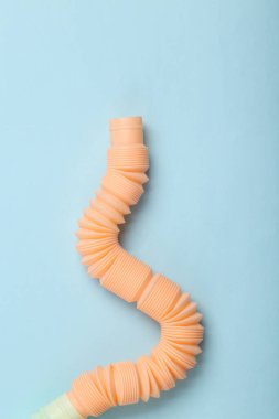 Antistretch pop tube toy on blue pastel background. Top view
