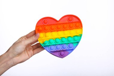 Hand holding Popular antistress pop it toy in the shape of heart isolated on white background