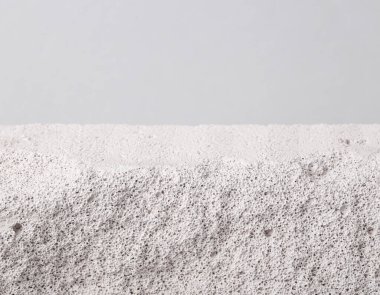 Stone porous platform on a gray background. Creative natural showcase