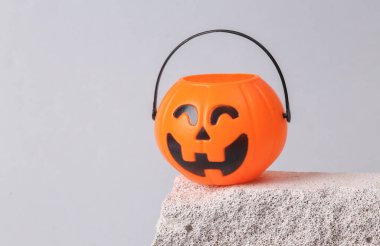 Halloween bucket on stone, gray background